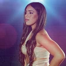 זמרת מזרחית שרה על במה באור צבעוני מול קהל שמוחא כפיים